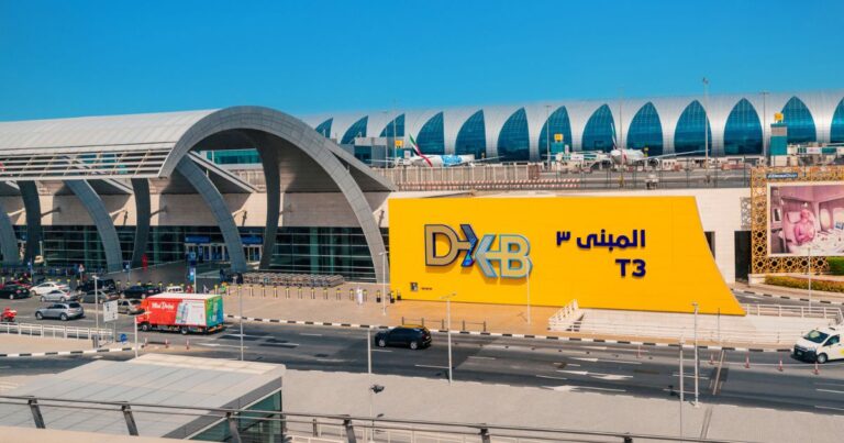 Dubai Airport baggage claim area with travelers collecting luggage