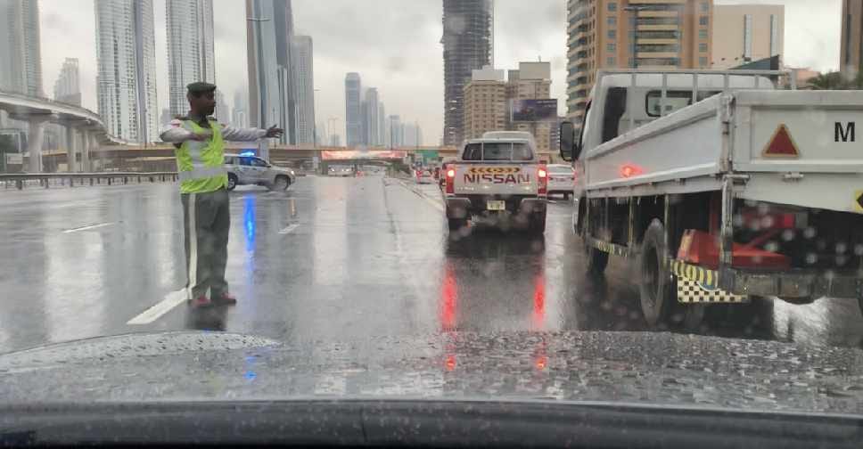 Dubai Traffic Police guiding the traffic on a rainy day