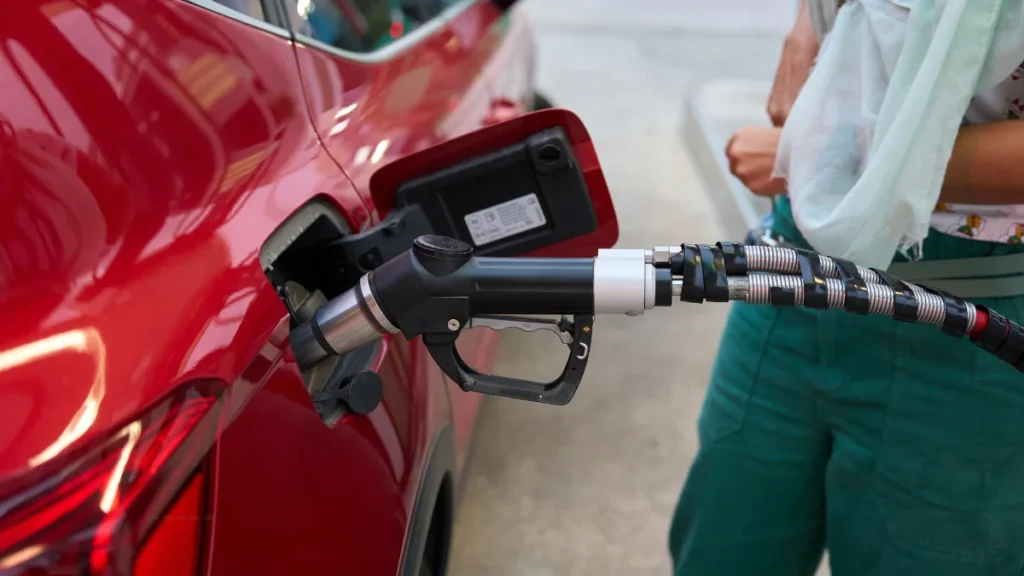 UAE petrol prices January 2026 anticipation showing a close-up of a fuel pump nozzle dispensing petrol into a car tank.