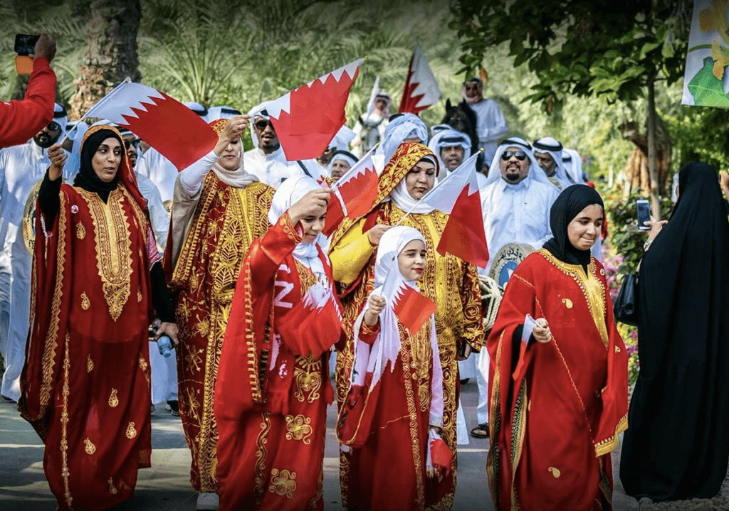 Children celebrating Bahrain Nation Day with their parents and Bahrain flag