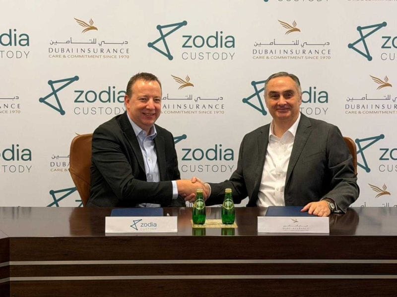 Executives shaking hands at the launch of UAE Crypto Insurance Payments in Dubai.