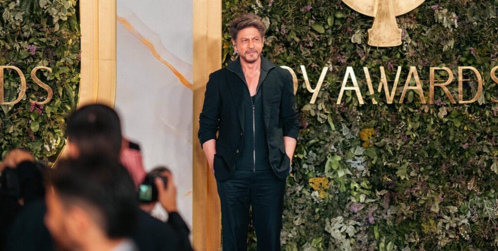 Shah Rukh Khan waving to fans on the lavender carpet at Joy Awards 2026